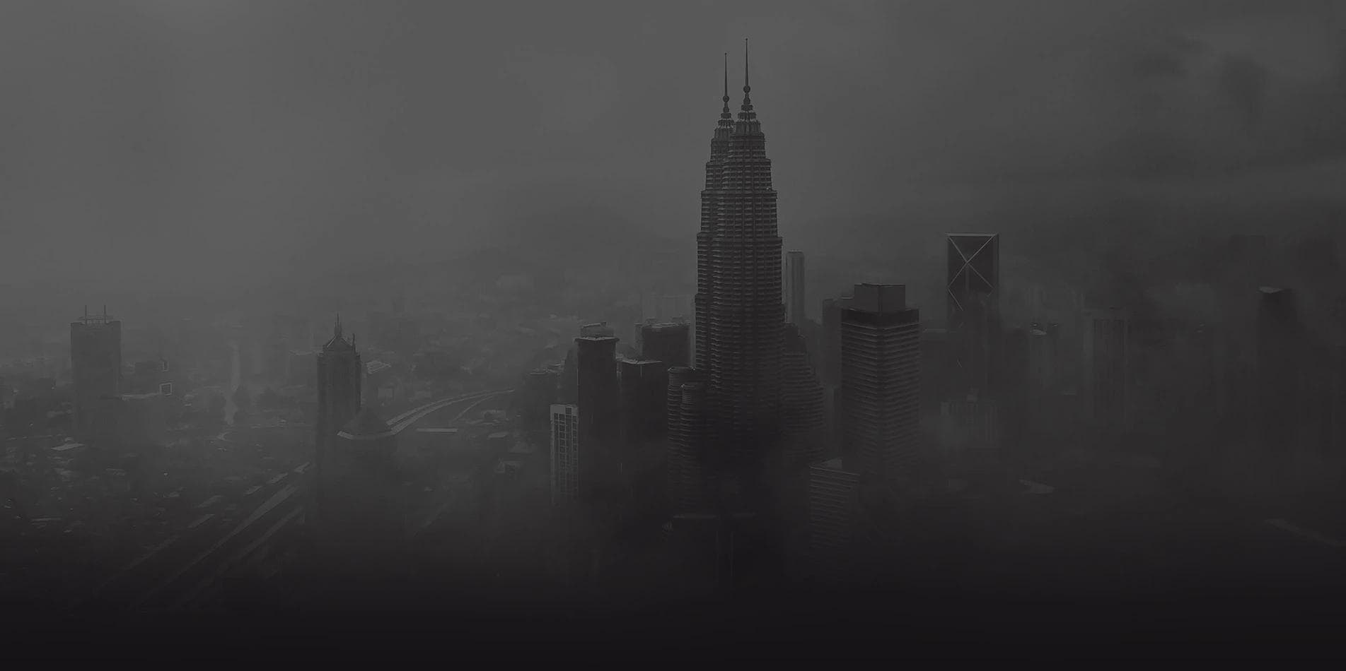 Kuala Lumpur skyline shrouded in mist, in dark monochrome