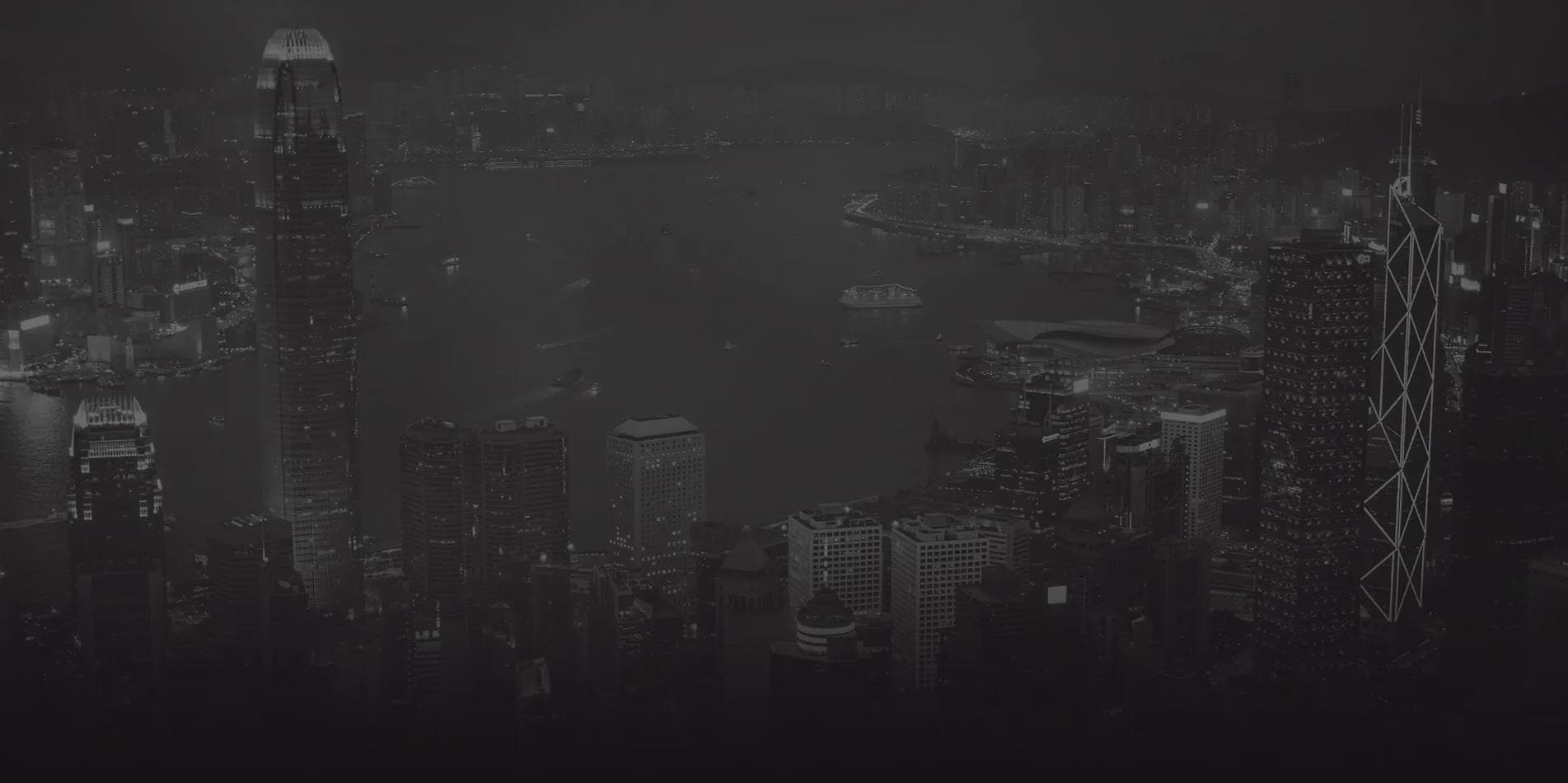 Hong Kong skyline and harbour at night, in dark monochrome